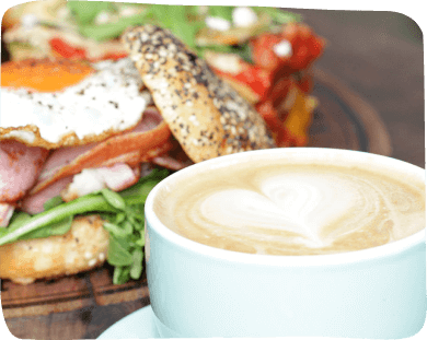 A sandwich served on a plate next to a cup of coffee, showcasing a simple yet enjoyable dining experience.