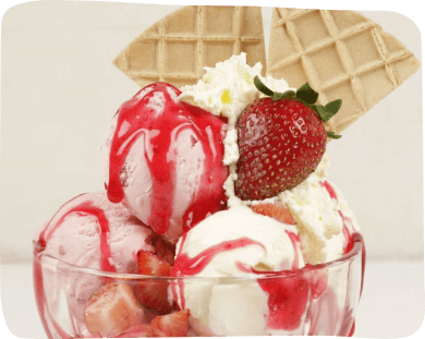 A bowl filled with creamy ice cream topped with fresh strawberries and a generous swirl of whipped cream