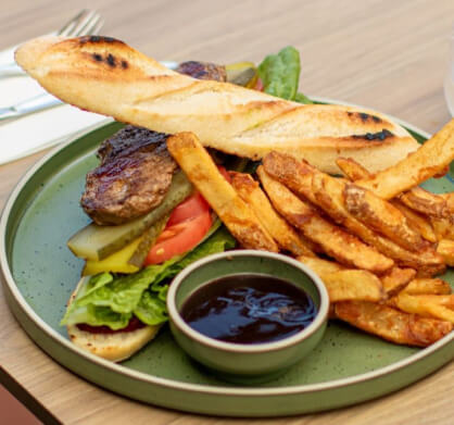 A delicious burger served on a plate with a side of crispy fries