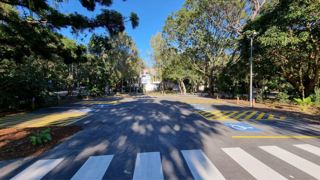 A parking lot featuring clearly marked yellow and white striped lines for vehicle parking and organization.