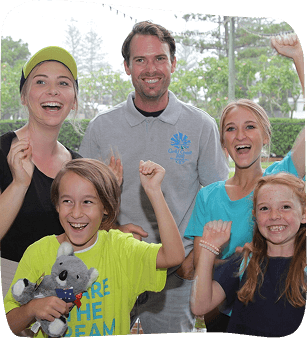 Excited family and friends, including children, celebrate a sporting event or achievement, with raised arms and smiles.