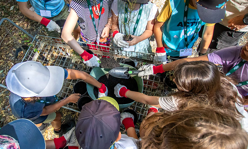Group of kids planting seeds in pot plants