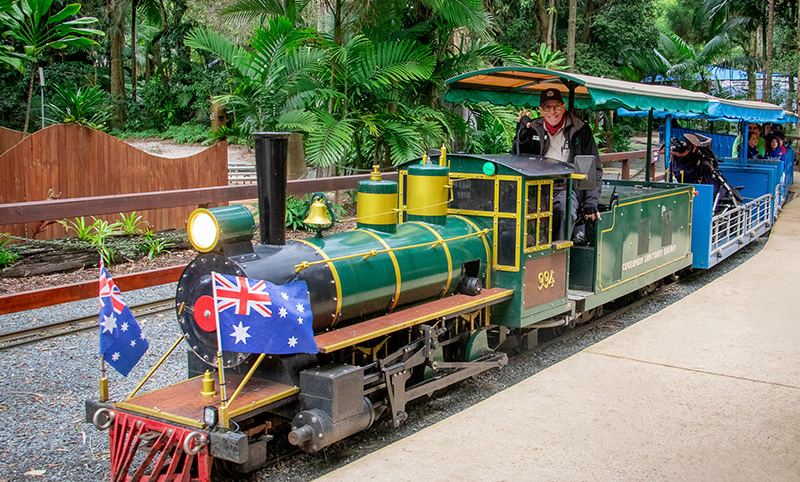 Green and blue miniature train at Currumbin Wildlife Sanctuary, train driver waving