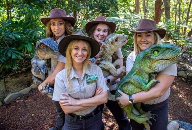 wildlife keepers holding baby dinosaur puppets
