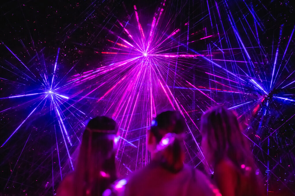 People watching purple and blue laser light show.