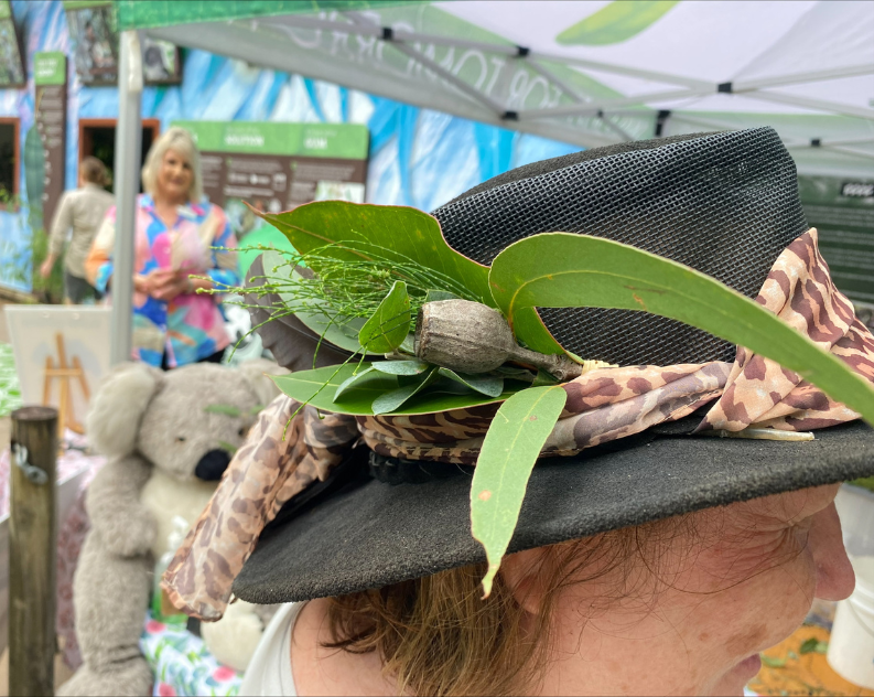 A close up of a woman's broad rim hat decorated with eucalyptus leaves and gumtree nut