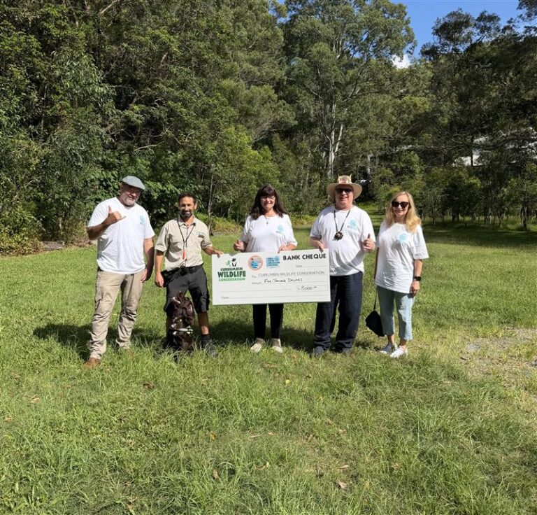Gold Coast World Surfing Reserve representatives presenting a $5,000 cheque to Currumbin Wildlife Sanctuary Conservation Detection Dog handler Mikey Vella.
