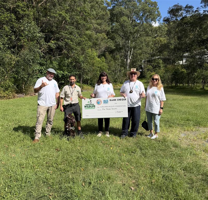 Gold Coast World Surfing Reserve representatives presenting a $5,000 cheque to Currumbin Wildlife Sanctuary Conservation Detection Dog handler Mikey Vella.